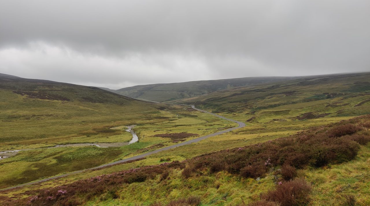 A burn meandering down a valley in the Lowther Hills — reading the bends and bars from above before you get in the water.