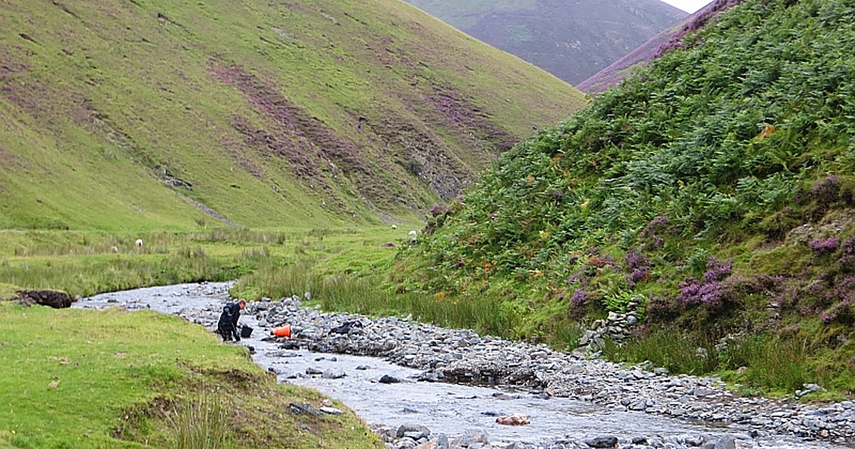 A gold panner working a gravel bar on the Mennock Water in the Mennock Pass near Wanlockhead, southern Scotland.