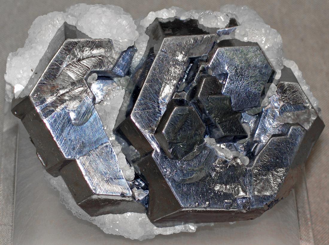 Bright silvery-grey galena crystals breaking into neat cubes, alongside white calcite.