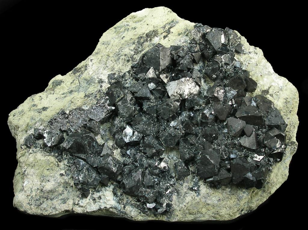 A specimen of black, metallic magnetite, the main component of the heavy black sand left in a gold pan.