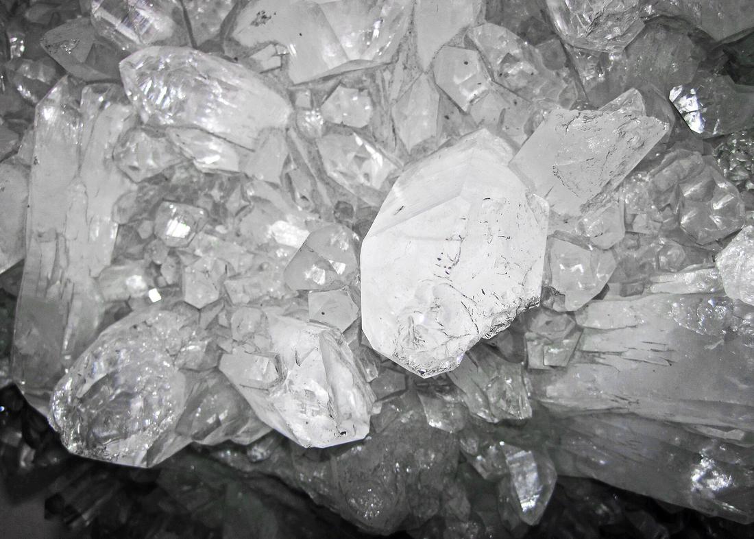 A cluster of white and colourless glassy quartz crystals with a greasy lustre.