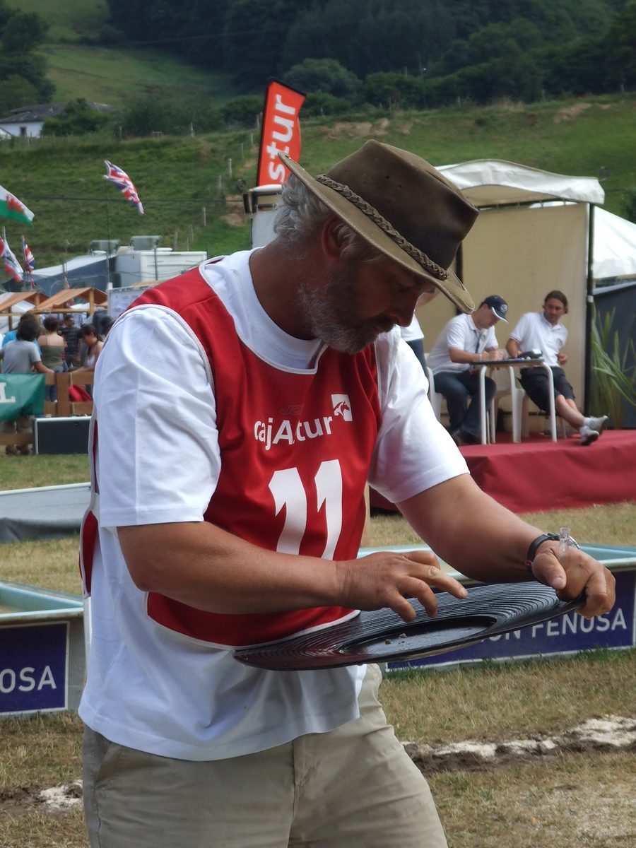 Vincent Thurkettle in a competitor's bib, number 11, working a gold pan at a gold panning championship.