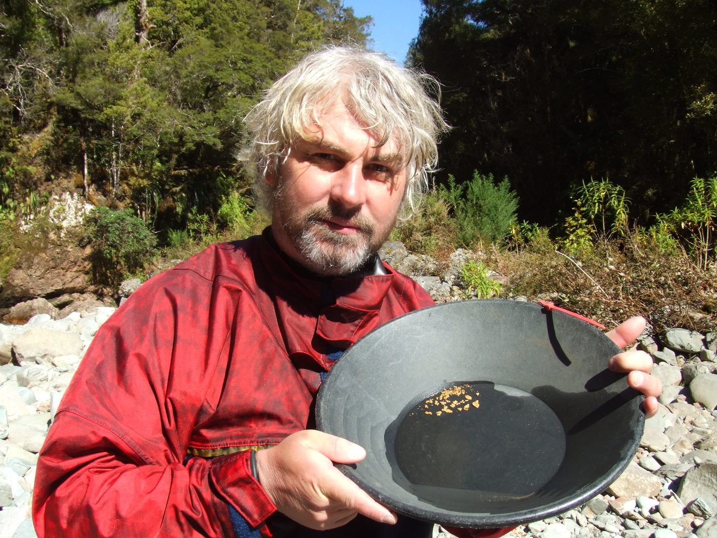 Vincent Thurkettle holding a gold pan with gold in it