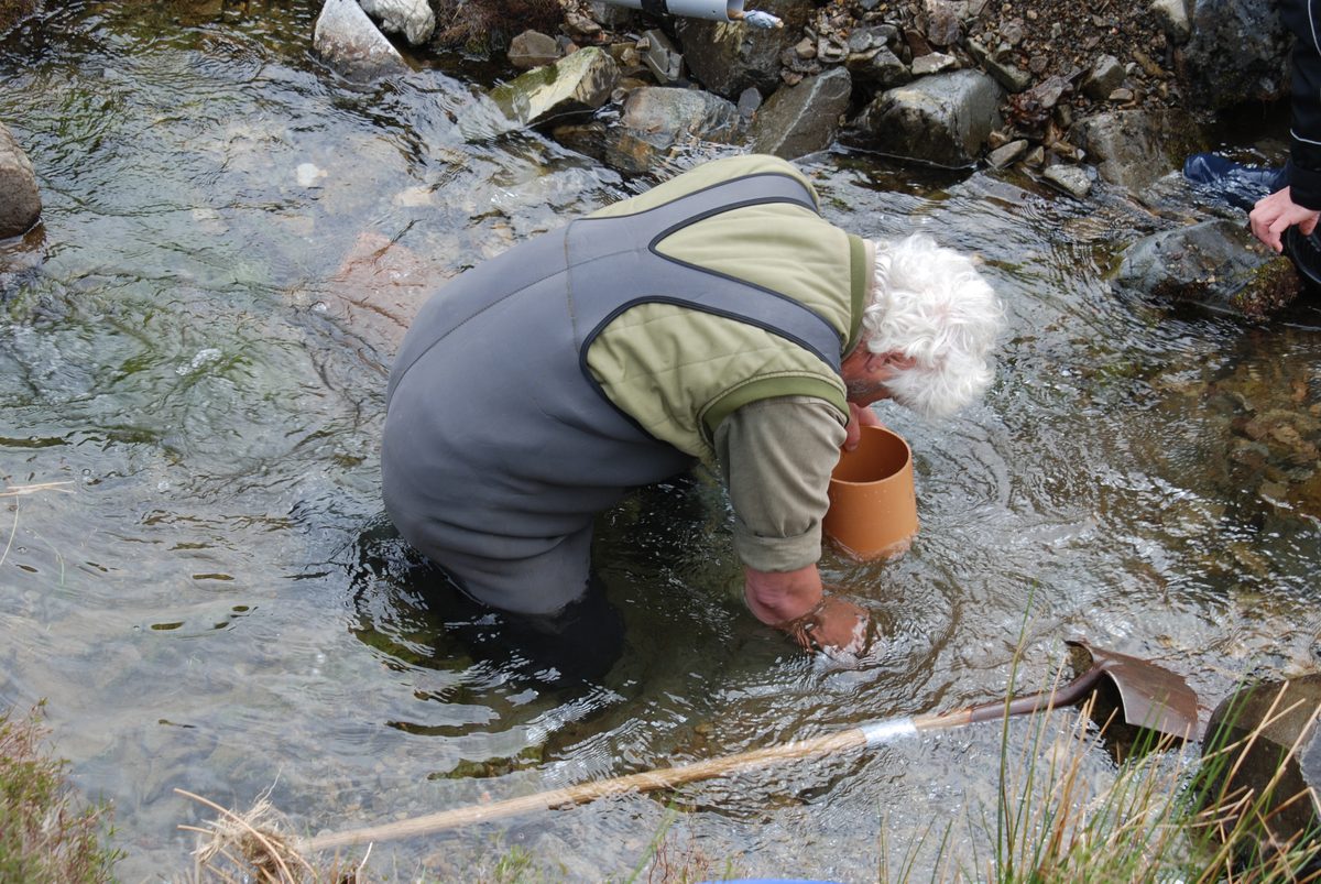 Vincent Thurkettle in a wetsuit, waist-deep in a shallow river.