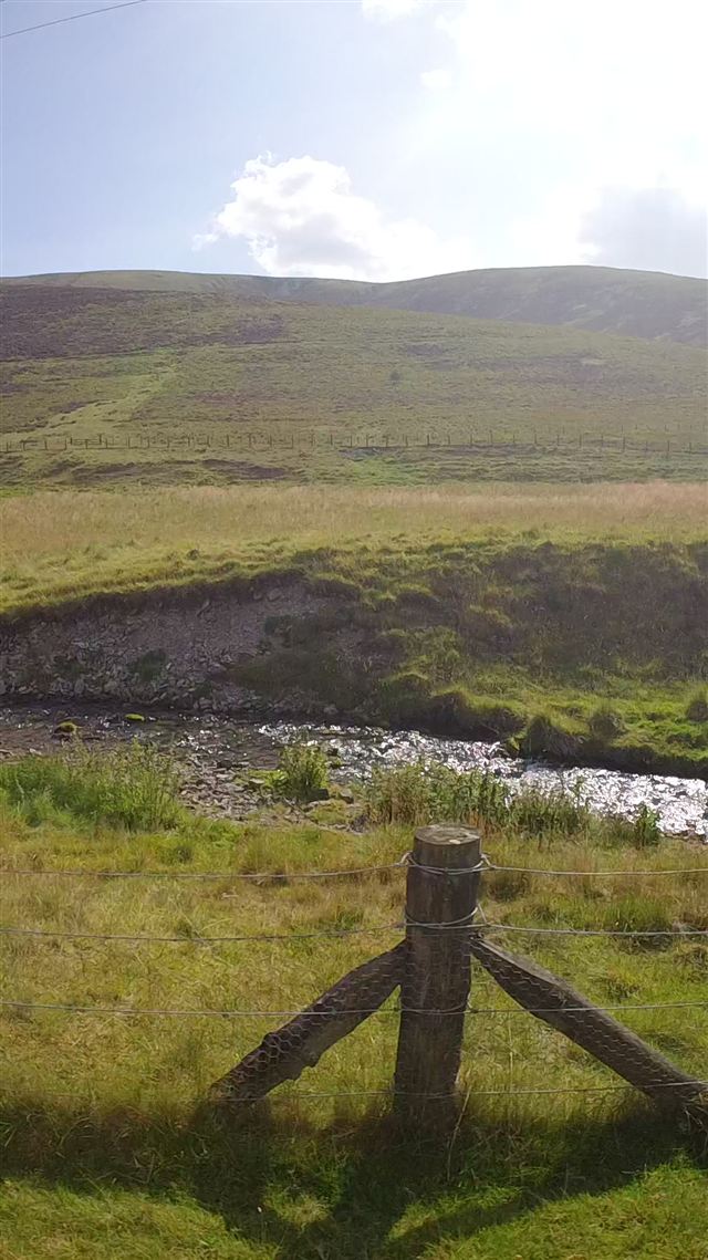 Open hills with a burn winding through the valley