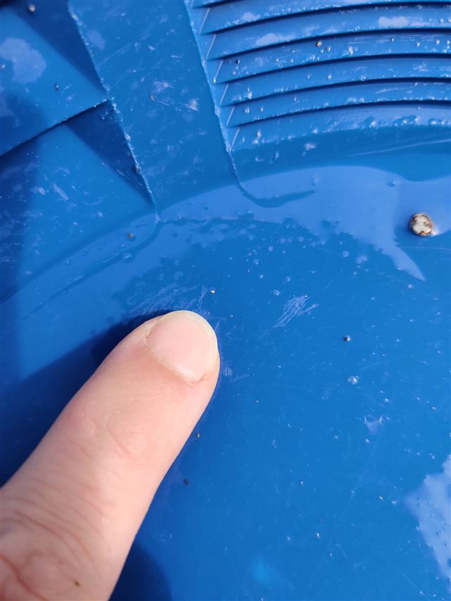 A flake of gold in the bottom of a blue gold pan